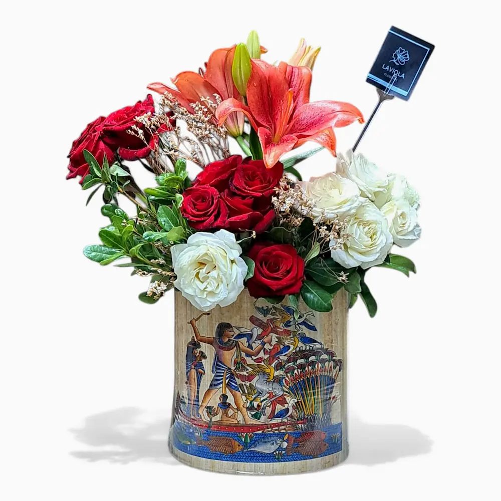 LaViola “Glory of Civilization” bouquet inspired by the Grand Egyptian Museum – red and white roses with orange lilies in a papyrus-wrapped vase.