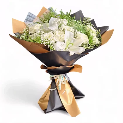 Elegant white hand bouquet featuring white lilies, white roses, and baby’s breath, wrapped in luxurious black and gold paper by LaViola Flowers